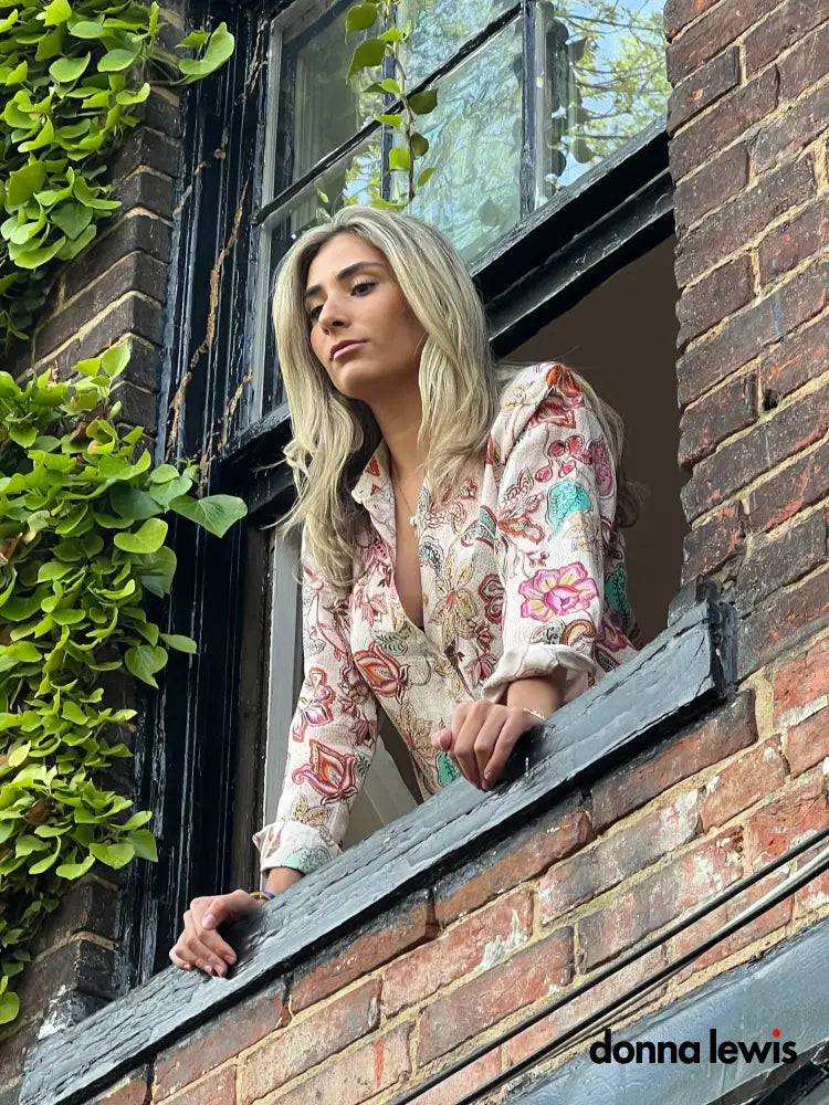Woman looking out of window with a Donna Lewis Blouse.